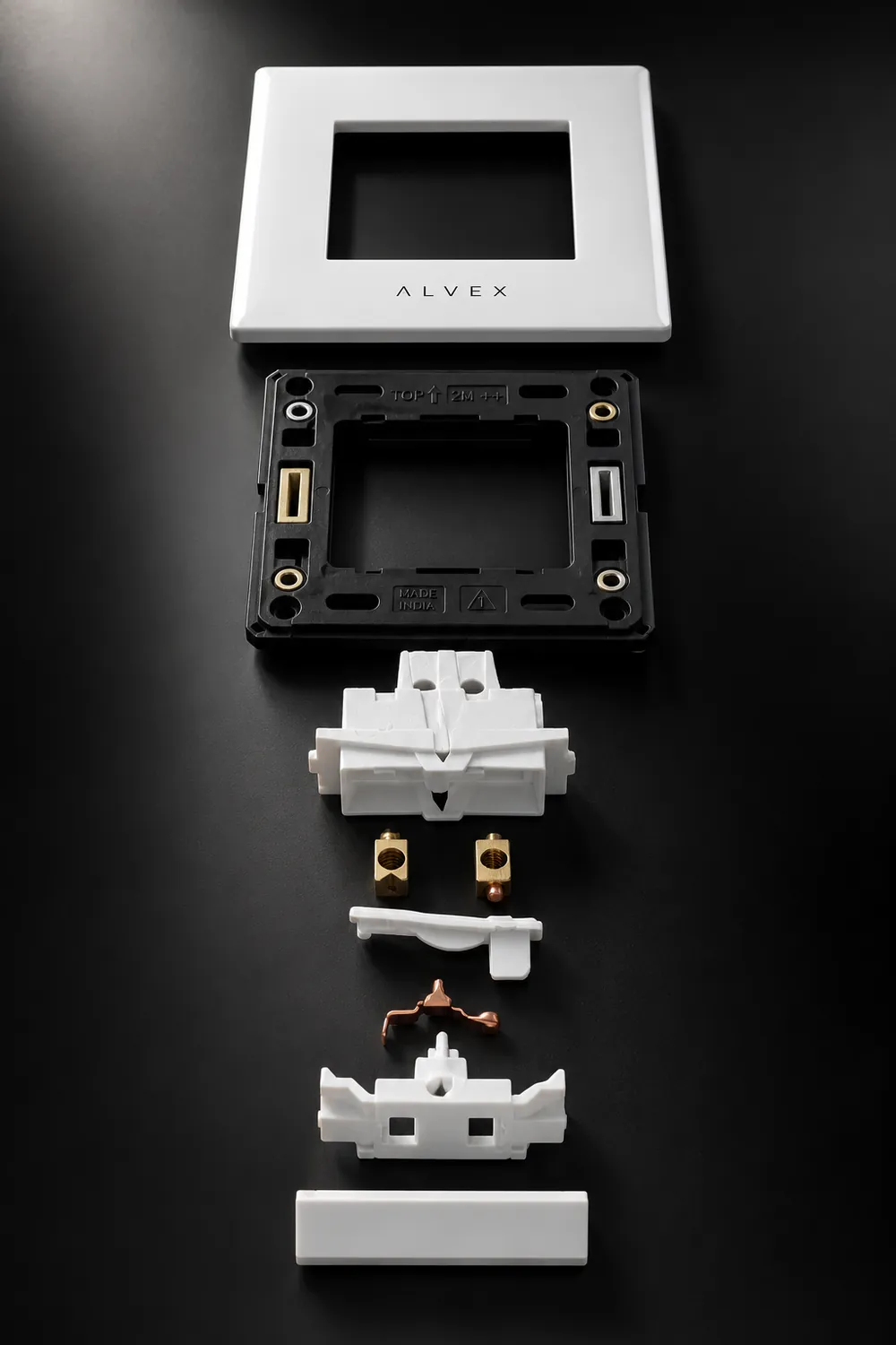 ALVEX Series X switch shown as an exploded assembly — front plate, mounting frame, housing, brass terminals, contact strip and rocker